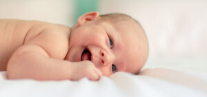 Picture of a smiling baby laying on a blanket